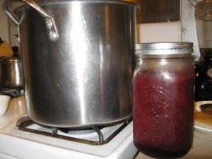 A quart jar of fresh blackberry juice next to my 3 gallon pot.